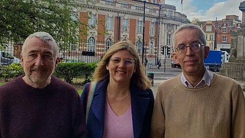 Photo of three people, two men and a woman